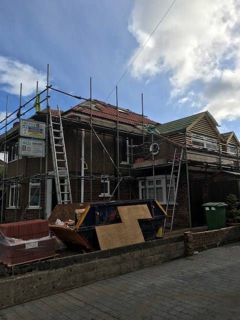 red brick house with scaffolding up for new roof